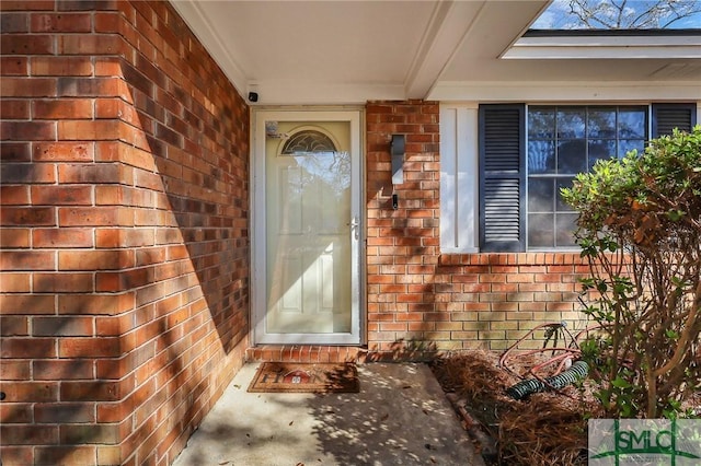 doorway to property featuring brick siding