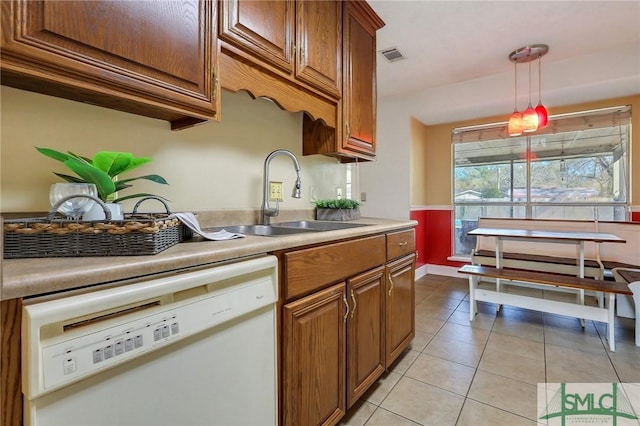 kitchen with visible vents, pendant lighting, a sink, light tile patterned flooring, and white dishwasher