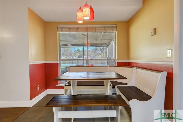 tiled dining room featuring baseboards