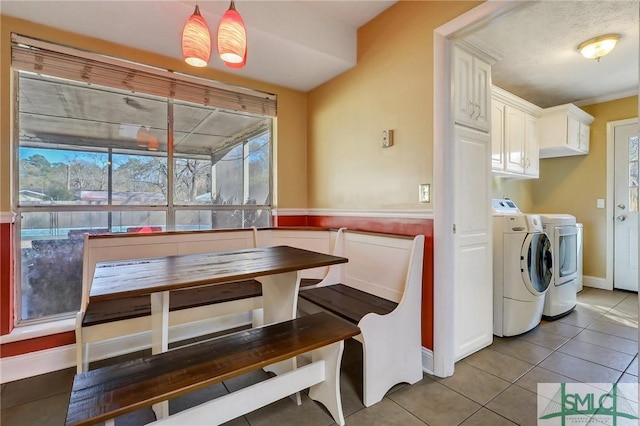 dining space with washer and dryer, light tile patterned flooring, baseboards, and breakfast area