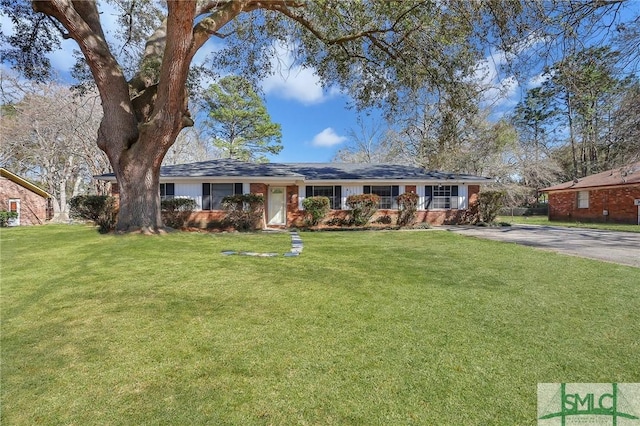 ranch-style home featuring a front lawn and driveway