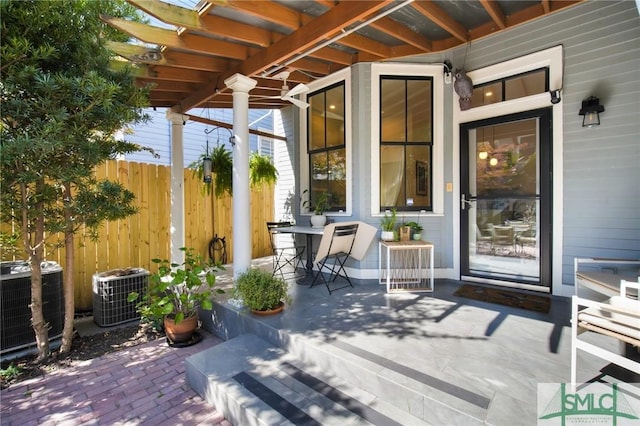 exterior space with a porch, central AC unit, and fence