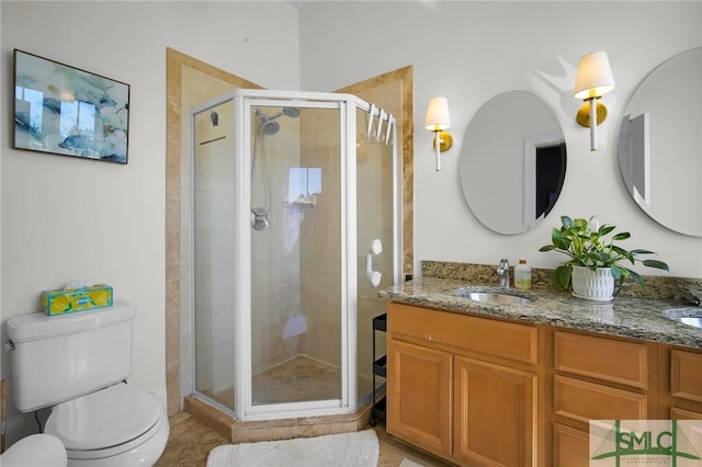 bathroom with a shower stall, toilet, double vanity, and a sink