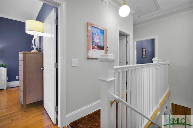 hall with attic access, wood finished floors, an upstairs landing, and baseboards