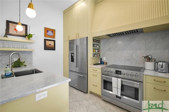 kitchen featuring cream cabinets, premium appliances, premium range hood, and a sink