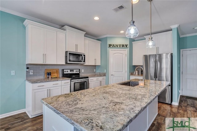 kitchen featuring visible vents, a sink, appliances with stainless steel finishes, white cabinetry, and crown molding