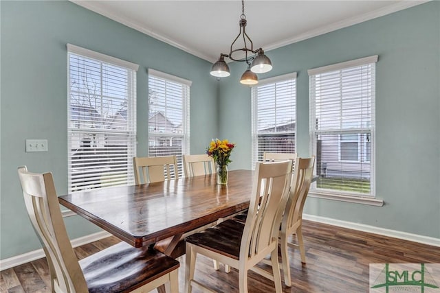 dining room with baseboards, an inviting chandelier, wood finished floors, and crown molding