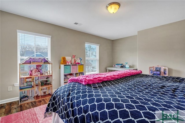 bedroom featuring wood finished floors, visible vents, and baseboards