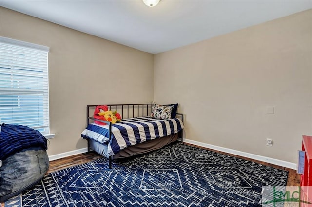 bedroom featuring baseboards and wood finished floors