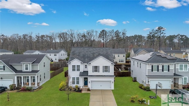 view of front of home featuring a residential view, an attached garage, driveway, and a front lawn