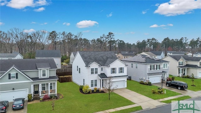 view of front of home featuring fence, a residential view, a front yard, a garage, and driveway