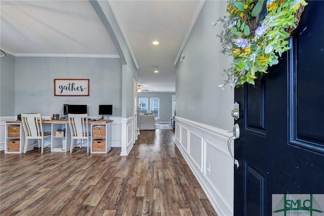 entrance foyer featuring a wainscoted wall, dark wood-style flooring, and ornamental molding