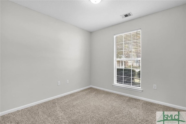 spare room featuring visible vents, carpet floors, and baseboards