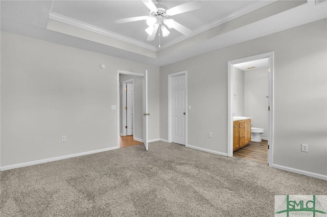 unfurnished bedroom with baseboards, a raised ceiling, carpet, and ornamental molding