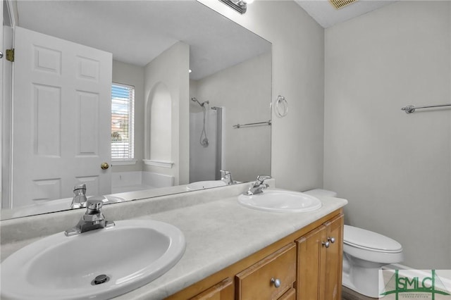 bathroom with double vanity, toilet, a shower, and a sink