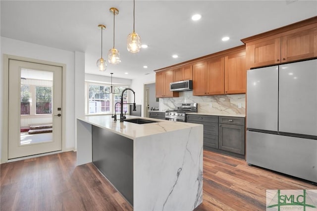 105 Carlton Rd, Savannah, GA 31410 - kitchen featuring appliances with stainless steel finishes, wood finished floors, tasteful backsplash, a kitchen island with sink, and recessed lighting
