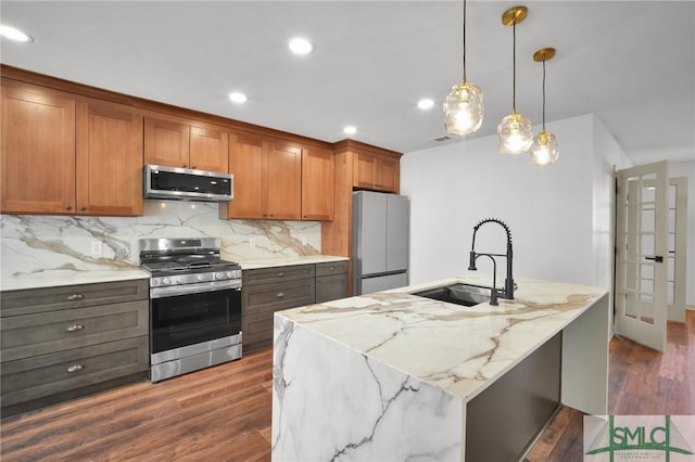 105 Carlton Rd, Savannah, GA 31410 - kitchen featuring appliances with stainless steel finishes, tasteful backsplash, dark wood finished floors, brown cabinets, and light stone countertops