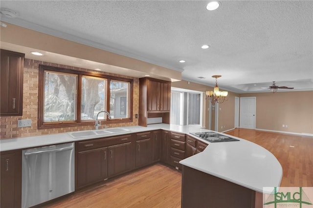 kitchen featuring light wood-style flooring, a peninsula, stainless steel dishwasher, black electric cooktop, and a sink