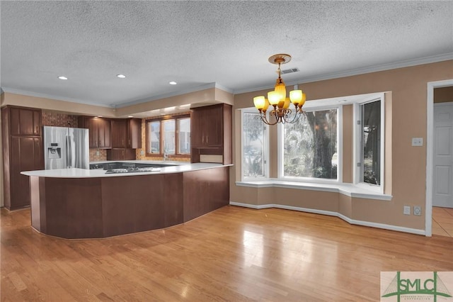 kitchen with a peninsula, light wood-style floors, and stainless steel refrigerator with ice dispenser