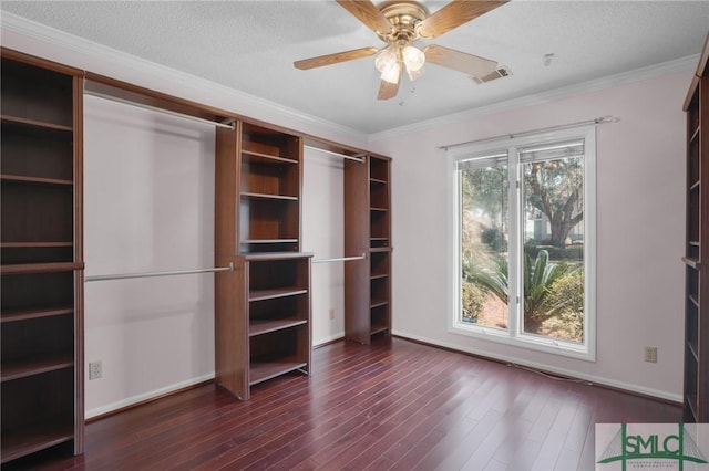 unfurnished bedroom featuring visible vents, crown molding, dark wood-type flooring, baseboards, and a textured ceiling