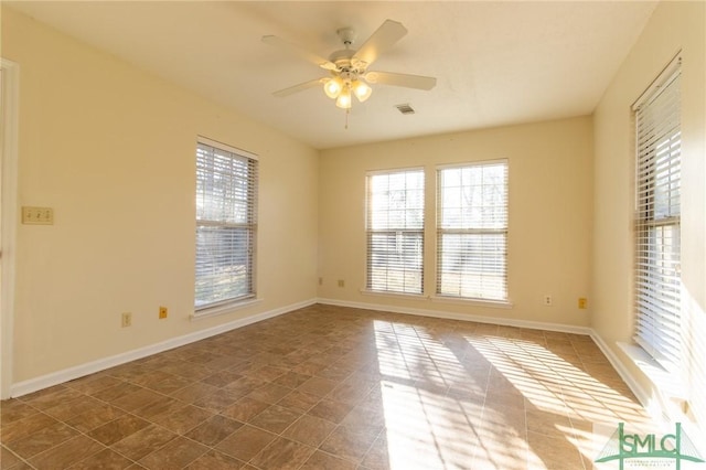 empty room featuring visible vents, baseboards, and a ceiling fan