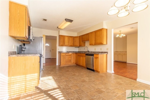 kitchen featuring visible vents, baseboards, appliances with stainless steel finishes, an inviting chandelier, and a sink