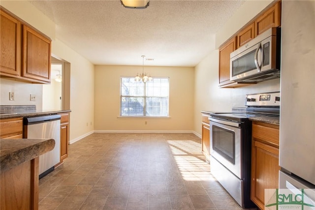 kitchen with stainless steel appliances, brown cabinets, dark countertops, and baseboards