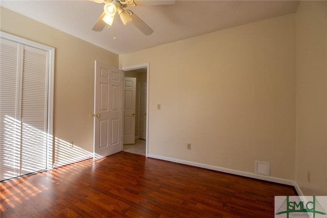 unfurnished bedroom featuring ceiling fan, a closet, baseboards, and wood finished floors