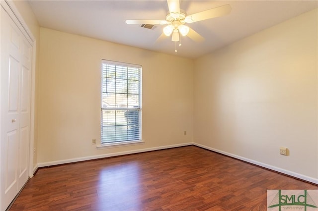 spare room featuring visible vents, baseboards, wood finished floors, and a ceiling fan