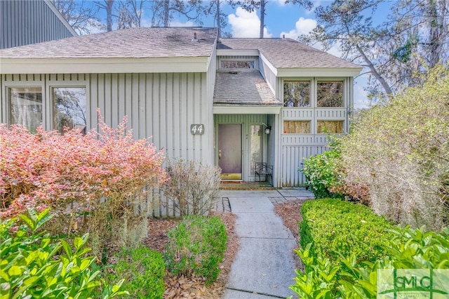 view of front of house with board and batten siding and a shingled roof