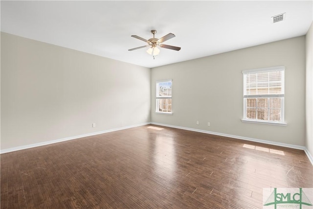 unfurnished room featuring visible vents, wood finished floors, baseboards, and ceiling fan