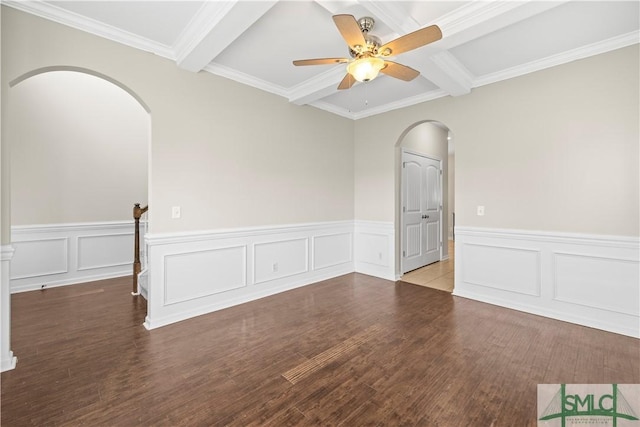 unfurnished room featuring wood finished floors, arched walkways, ceiling fan, wainscoting, and beamed ceiling