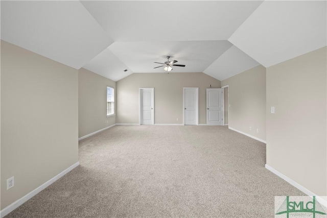 unfurnished room featuring carpet flooring, baseboards, ceiling fan, and vaulted ceiling