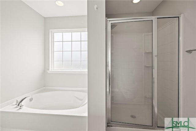 bathroom featuring a bath, recessed lighting, and a stall shower