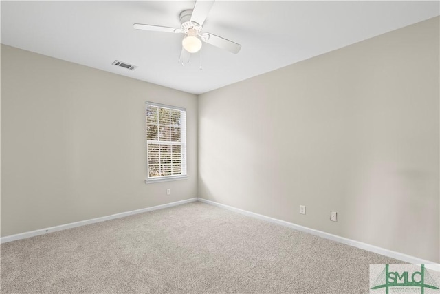 carpeted spare room with visible vents, baseboards, and ceiling fan