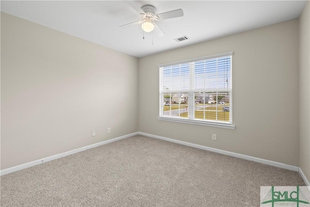 carpeted empty room featuring visible vents, baseboards, and a ceiling fan