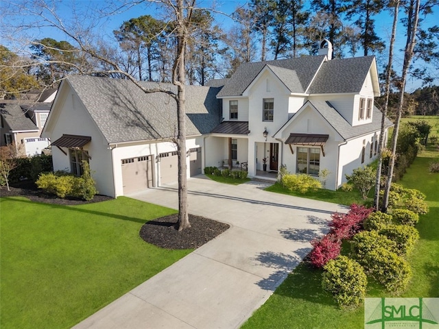 modern inspired farmhouse with a front yard, driveway, a standing seam roof, an attached garage, and metal roof