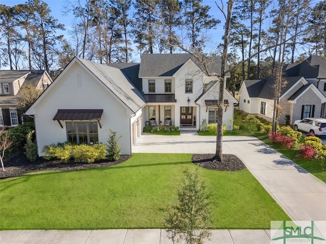 view of front of property featuring metal roof, a residential view, a front lawn, and a standing seam roof