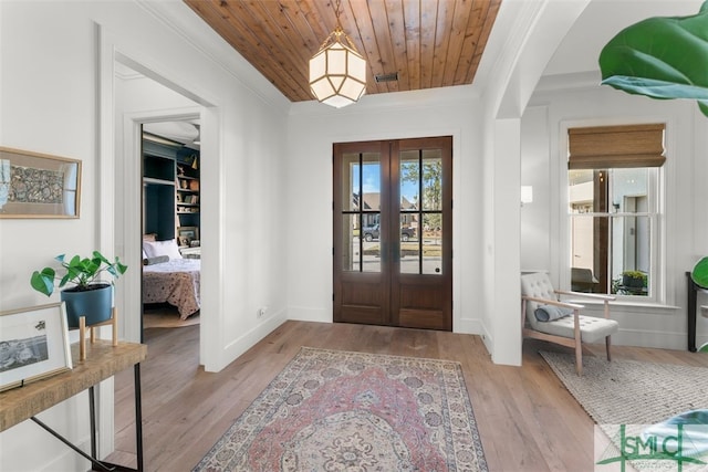 foyer featuring visible vents, wood ceiling, ornamental molding, french doors, and wood finished floors