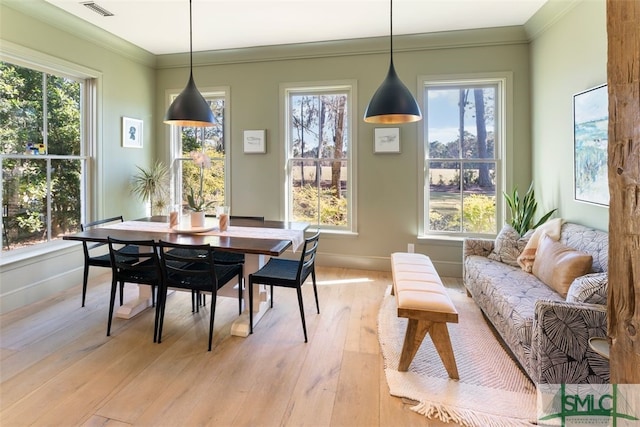 dining space featuring light wood-style flooring, plenty of natural light, visible vents, and ornamental molding