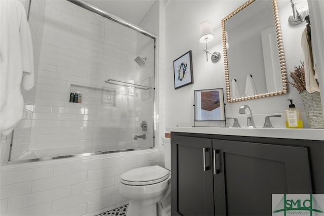 bathroom with toilet, vanity, and tiled shower / bath combo