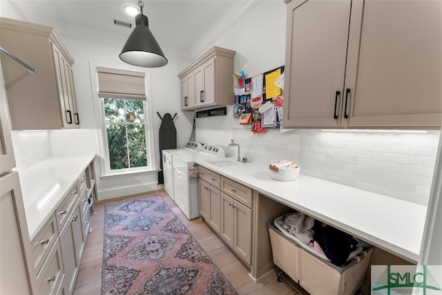 kitchen with tasteful backsplash, ornamental molding, light countertops, and separate washer and dryer