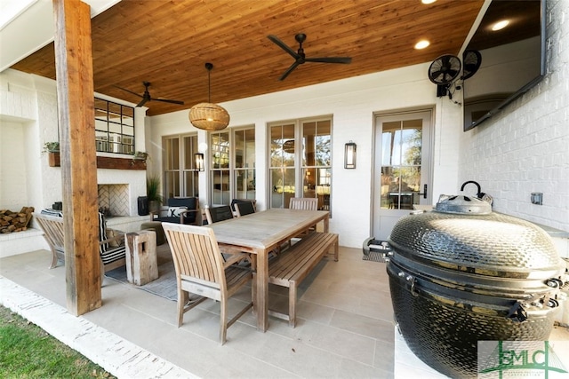 view of patio featuring grilling area, outdoor dining area, and a ceiling fan