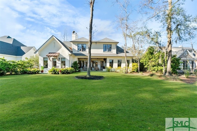 back of property with a yard and a chimney