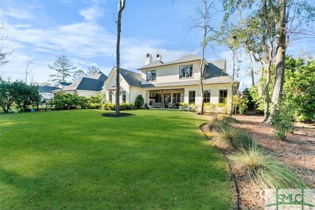 rear view of property featuring a yard