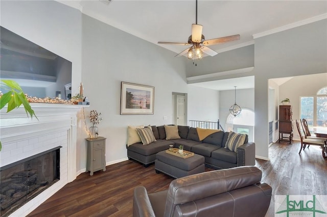 living room featuring a brick fireplace, baseboards, and dark wood-style flooring