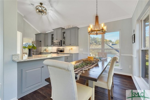 dining space with an inviting chandelier, plenty of natural light, crown molding, and lofted ceiling