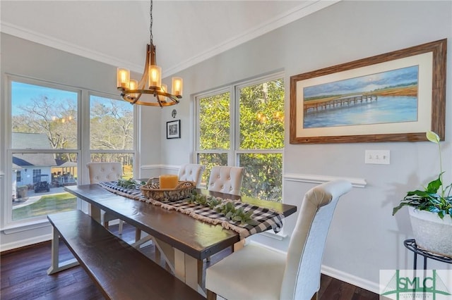 dining area featuring dark wood finished floors, crown molding, baseboards, and an inviting chandelier