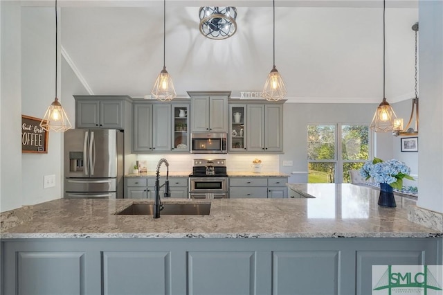 kitchen featuring gray cabinetry, ornamental molding, a sink, backsplash, and stainless steel appliances