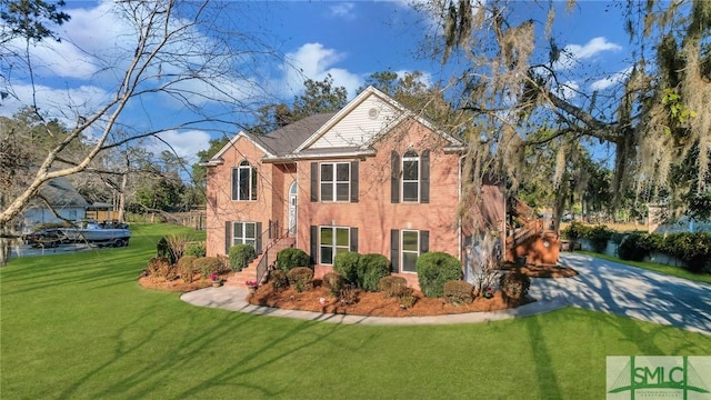 view of front of property featuring brick siding and a front yard